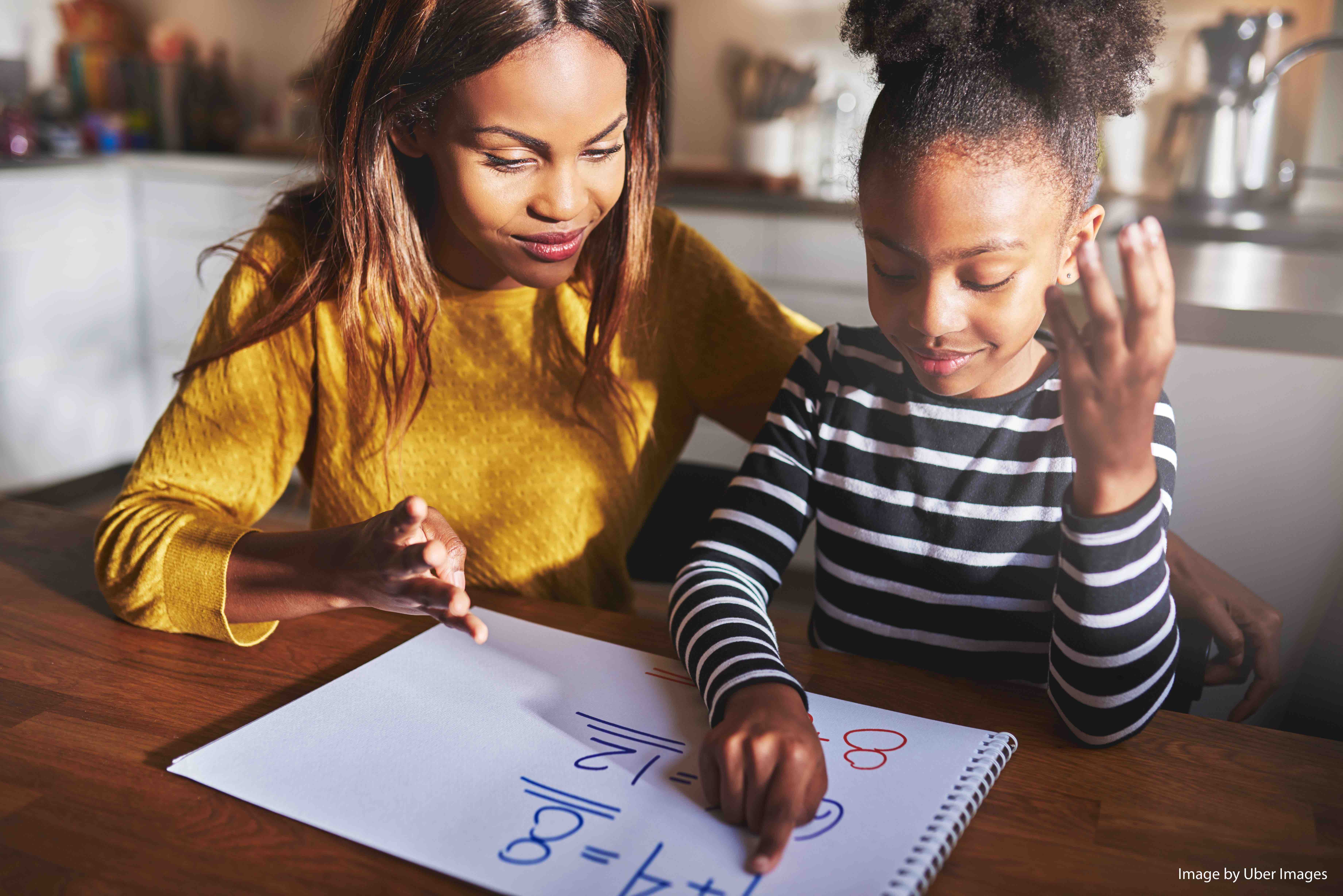 Mother and daughter doing homework learning to calculate