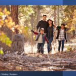 Family walking toward camera in autumn woods