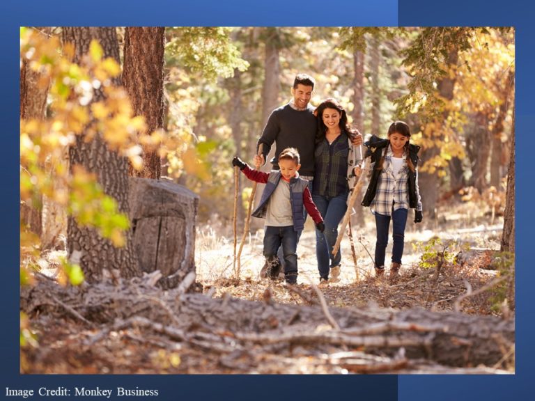 Family walking toward camera in autumn woods