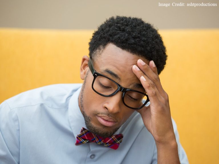 African American student wearing a bow tie, hand to forehead, looking frustrated and disappointed