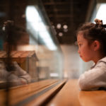 Young girl looking intently into a museum display case