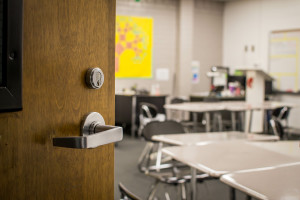 Looking past the door handle into an empty classroom