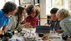 Group of middle-school children working with electrical equipment and an ipad