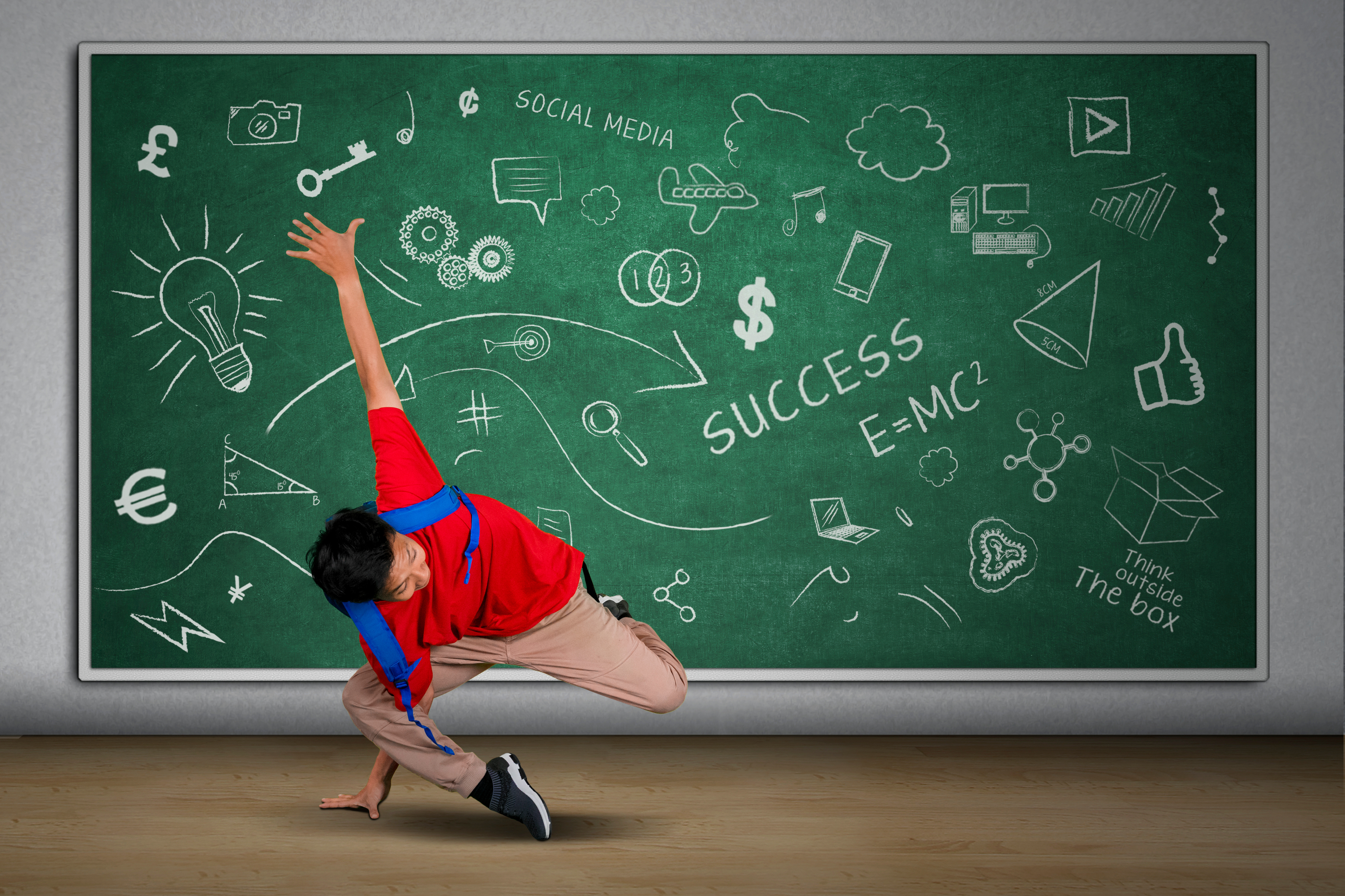 Picture of a student doing acrobatic movement in the classroom while carrying backpack with doodles on the blackboard