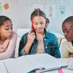 3 middle school students working together on a problem from a textbook